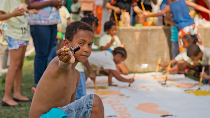 Em uma das oficinas, os moradores aprenderam como fazer tinta com ingredientes naturais e se divertiram testando os produtos.  Foto: William Gomes